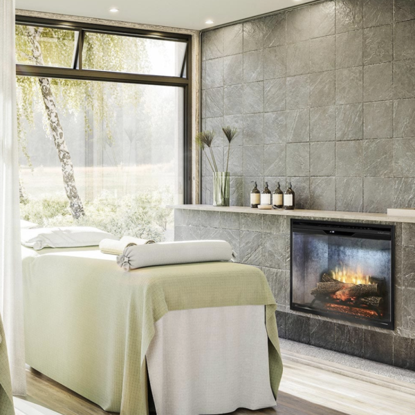 a spa with a massage table next to an electric fireplace