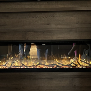 electric fireplace in walnut wood media wall with two children giving the thumbs up sign