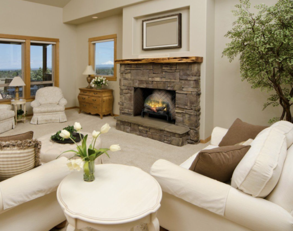 electric log set in a stone fireplace in a living room with light colored furniture